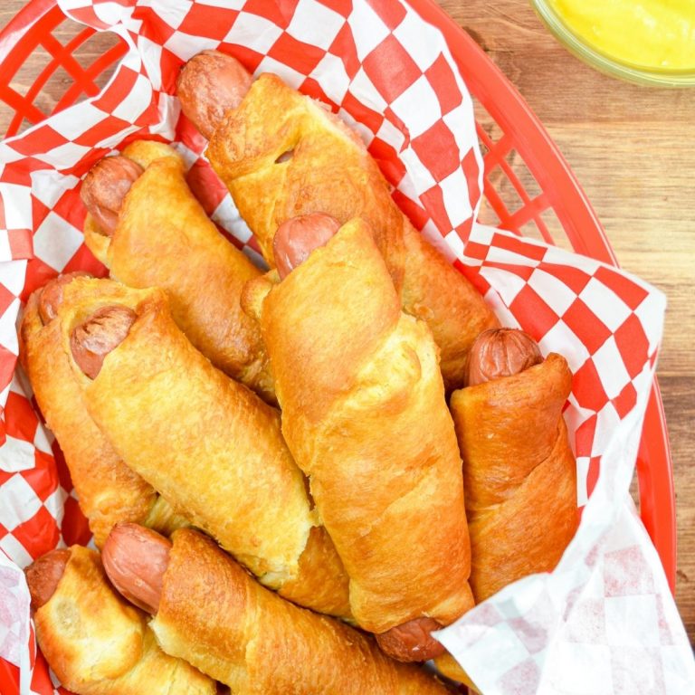 A basket of pigs in a blanket in a red basket.