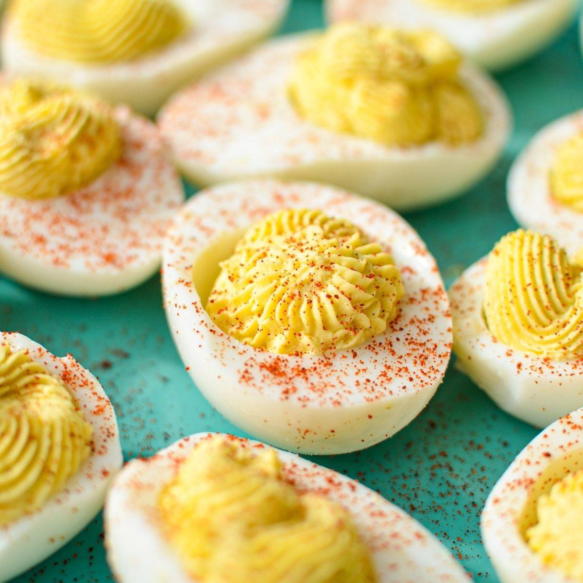 A close up of deviled eggs, sprinkled with paprika.