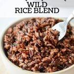 A bowl of wild rice with a fork taking a portion out.