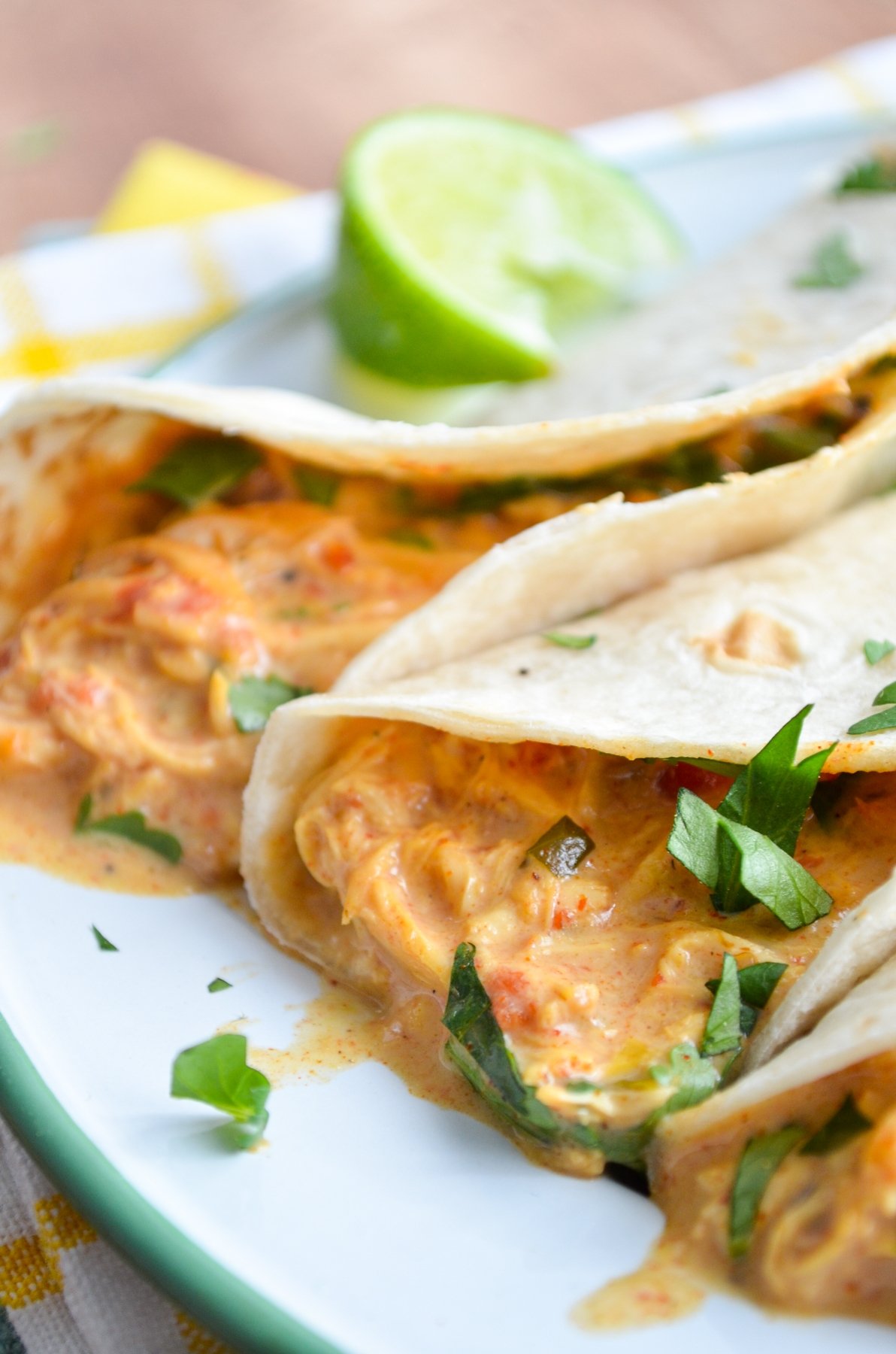 Queso Chicken Tacos, garnished with lime and cilantro.