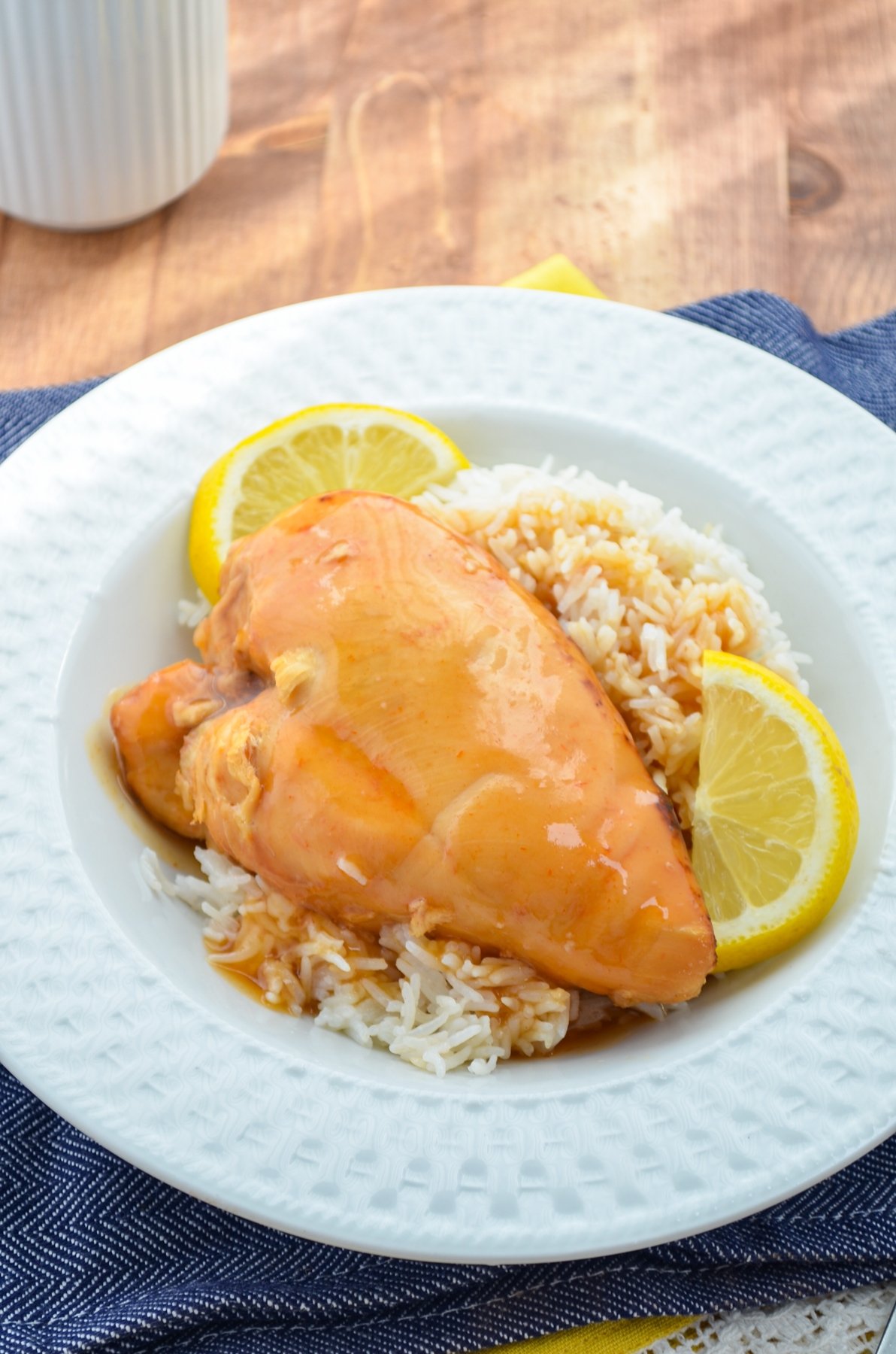 Slow cooker lemonade chicken, served over rice with lemon wedges.