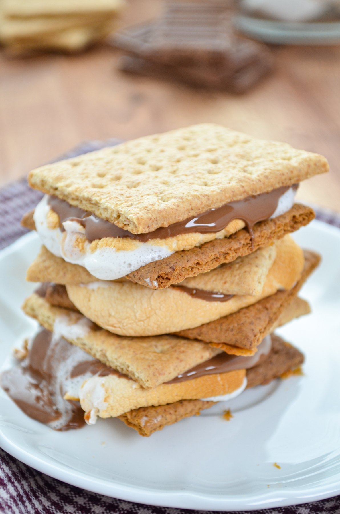 A stack of three s'mores on a white plate. 
