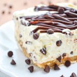Mini chocolate chips scattered around a no bake chocolate chip cheesecake.
