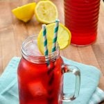 A glass of Passion Tea Lemonade, garnished with lemon wedges.