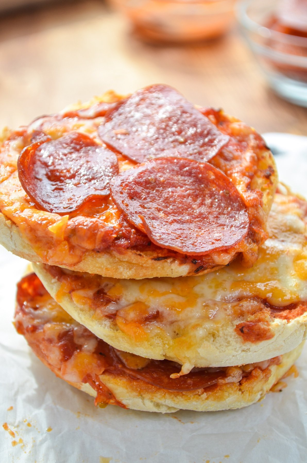 A stack of three english muffin pizzas.