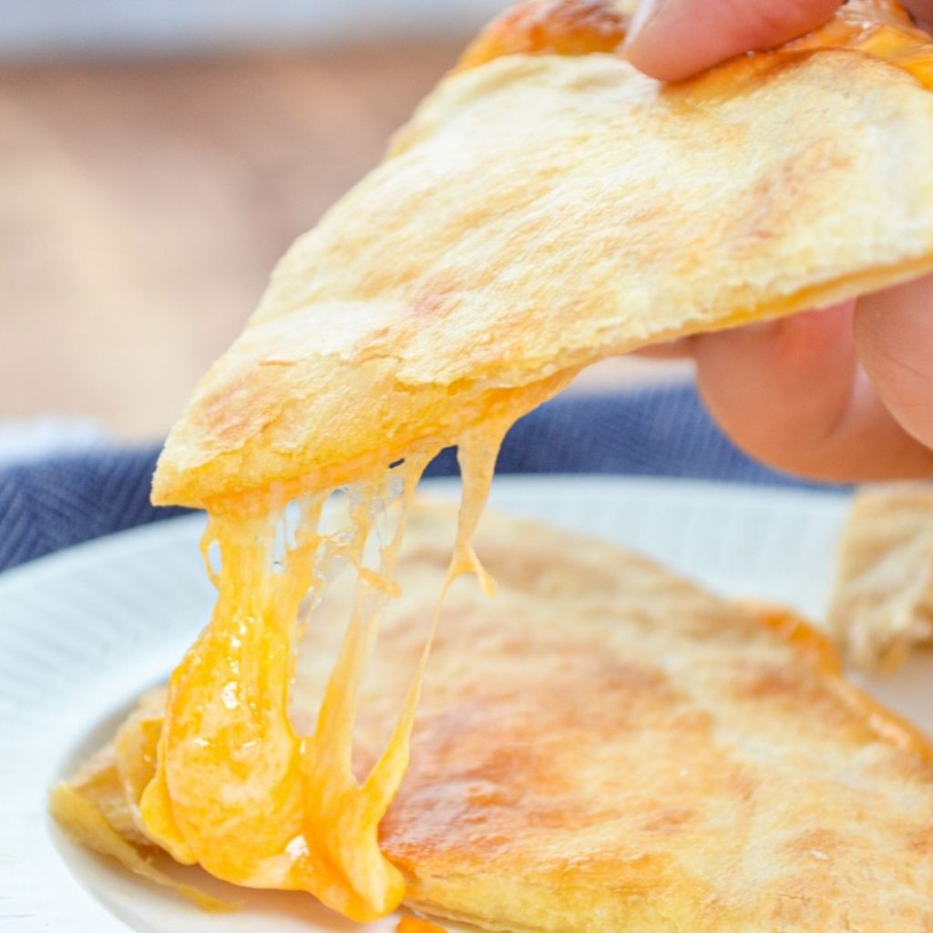 An air fryer quesadilla, with a big stretch of cheese.
