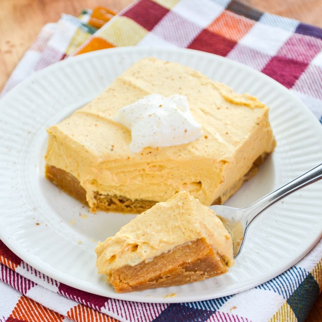 A fork with a portion of no bake pumpkin cheesecake bars.