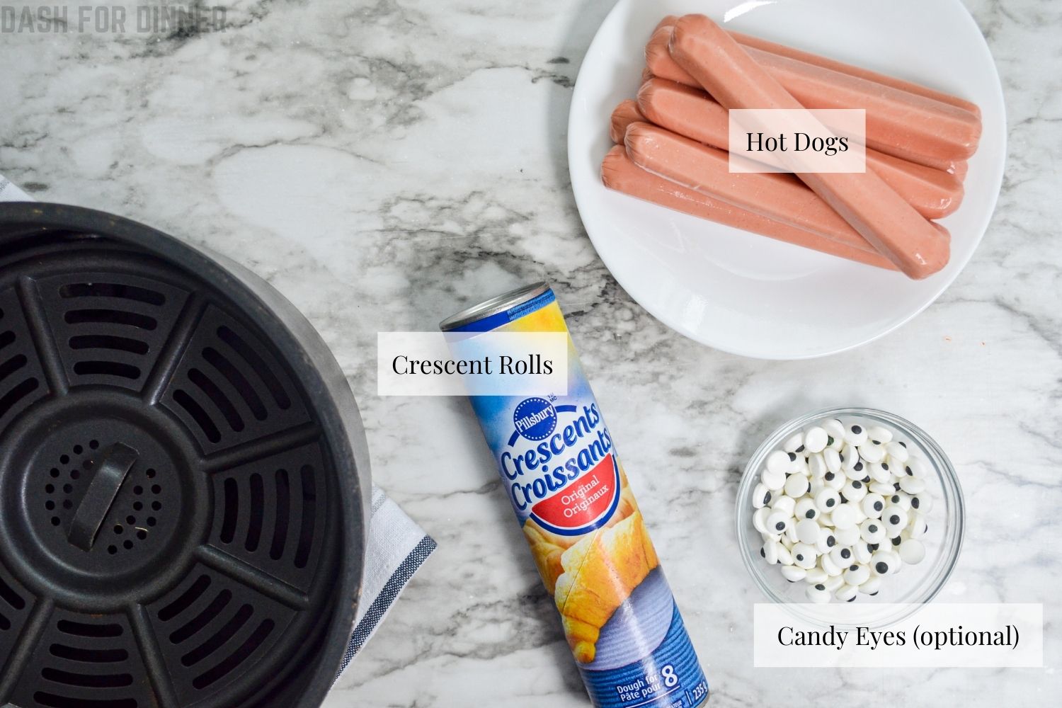 The ingredients needed to make mummy dogs in the Air Fryer: hot dogs, crescent rolls, and candy eyes.