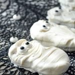 A nutter butter cookie, coated in white candy coating and dotted with two candy eyes.