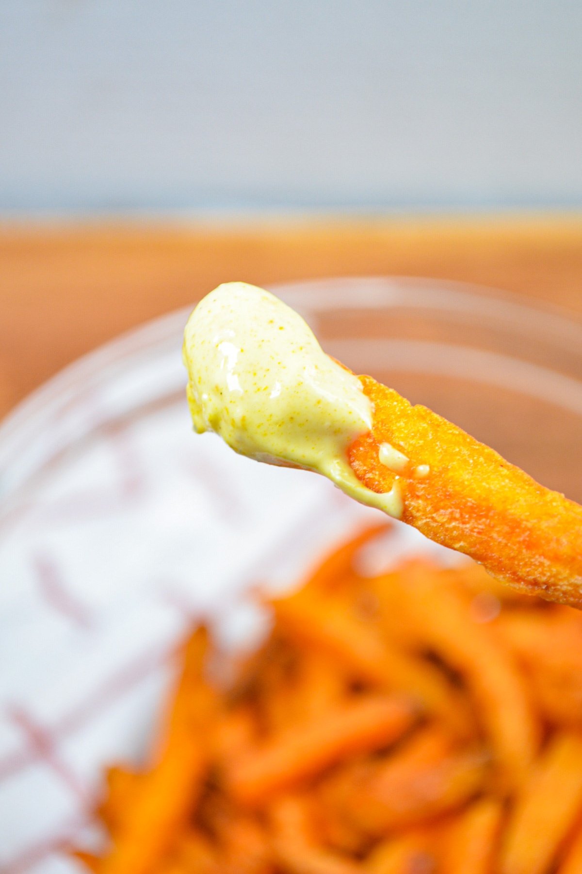 A sweet potato fry, dipped into curry mayo.