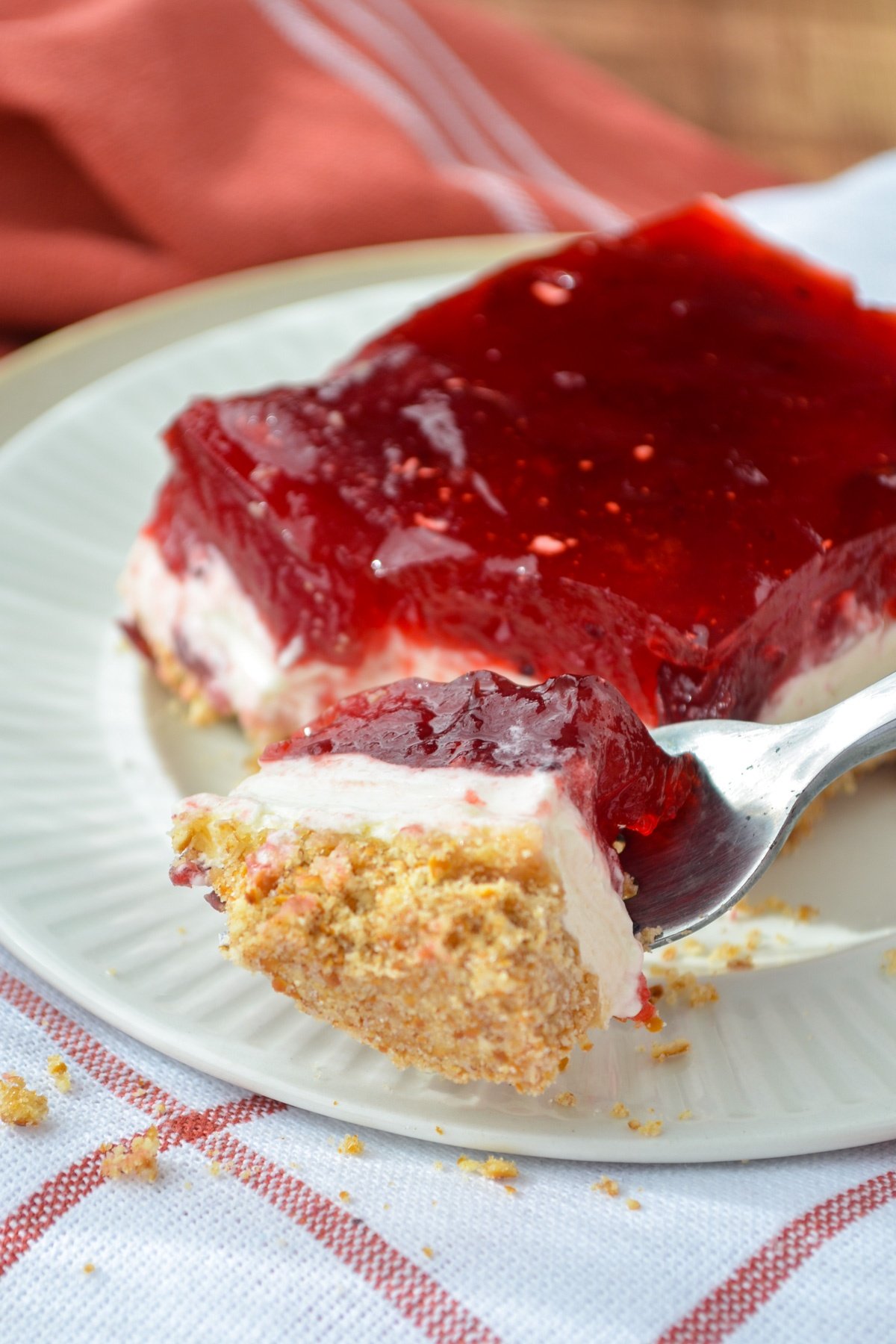 A fork taking a piece of layered cranberry dessert.