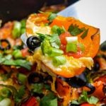 A spatula lifting out a portion of pepper nachos.
