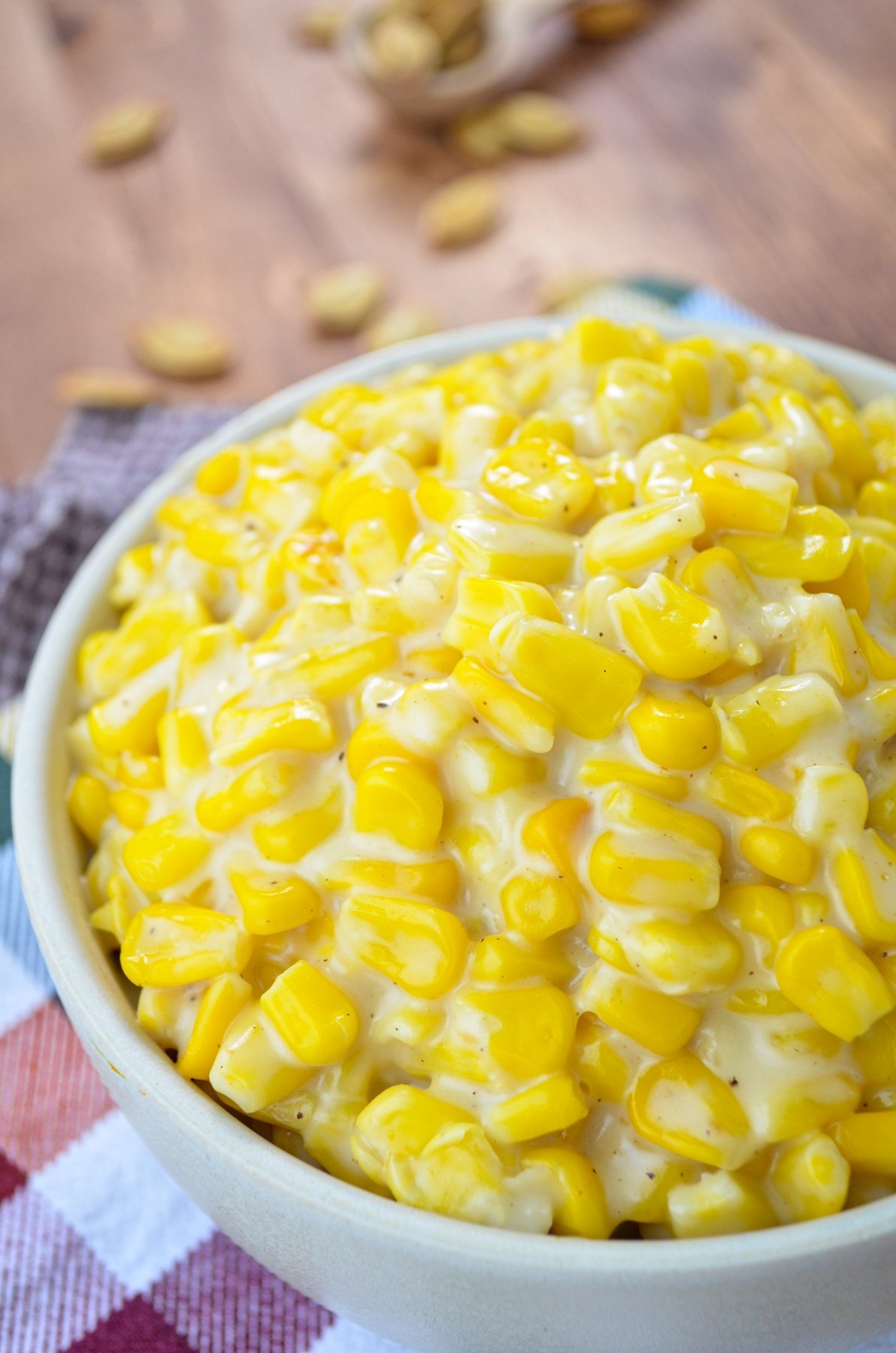 A bowl of creamed corn, resting on colorful napkins.