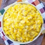 A bowl of creamed corn, resting on two fall inspired cloth napkins.