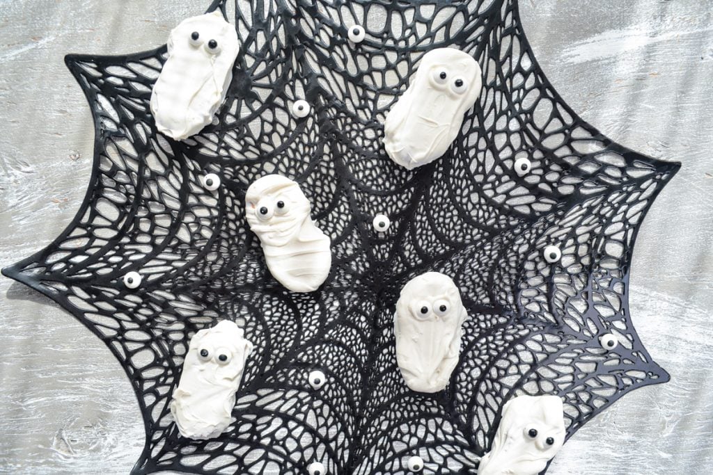 Nutter Butter ghost cookies on a spiderweb placemat.