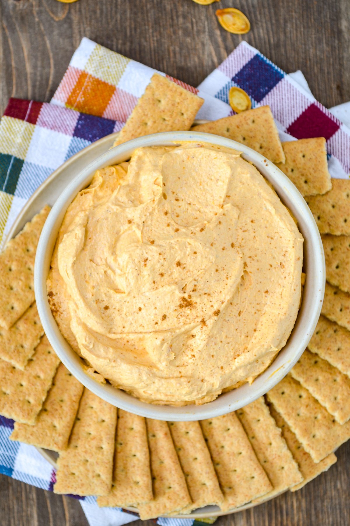 A bowl of pumpkin fluff dip, surrounded by graham crackers.