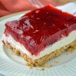 A slice of a three layer dessert with a pretzel base.