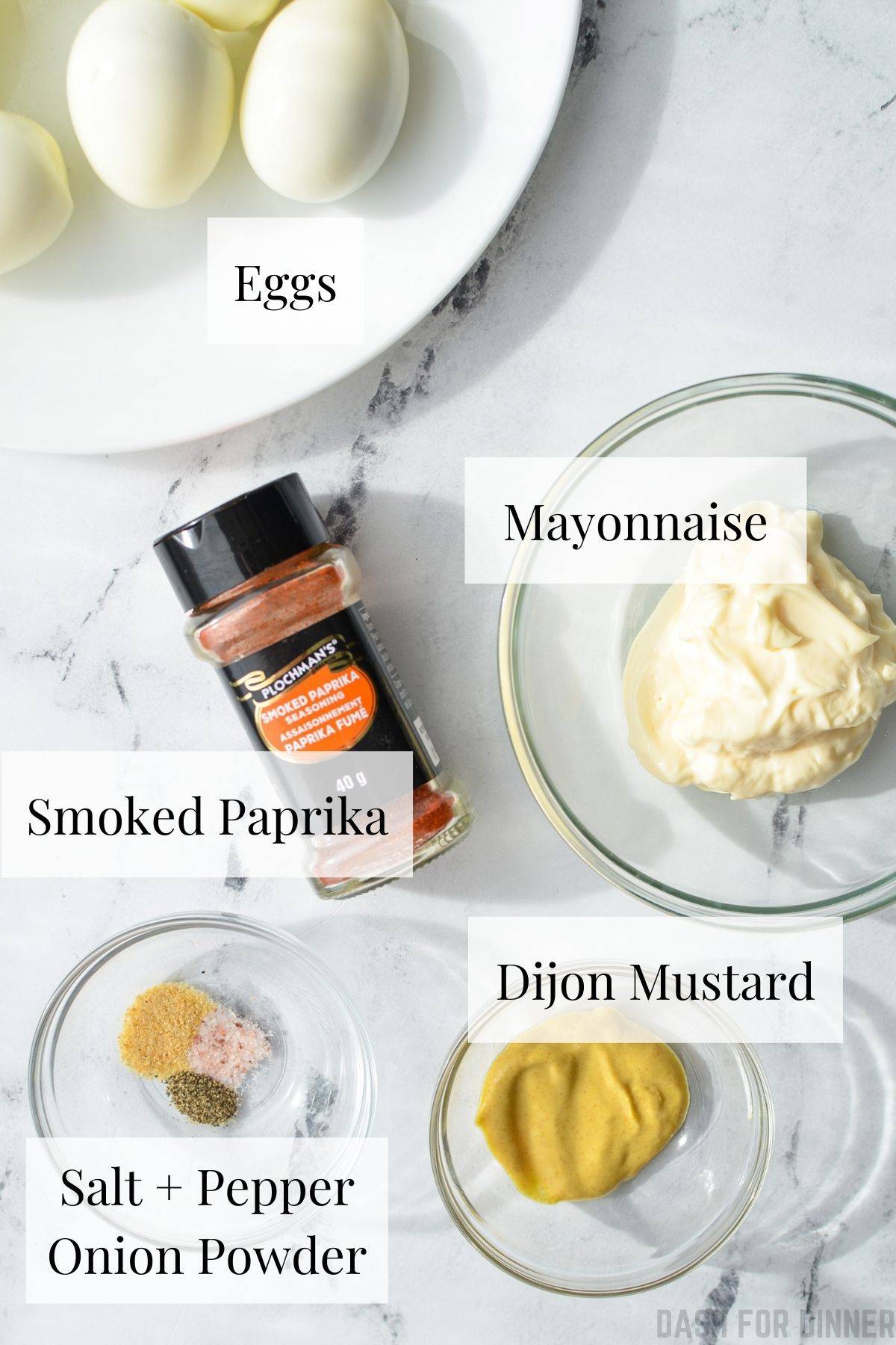 The ingredients needed to make deviled eggs, including hard boiled eggs, mayonnaise, and paprika.