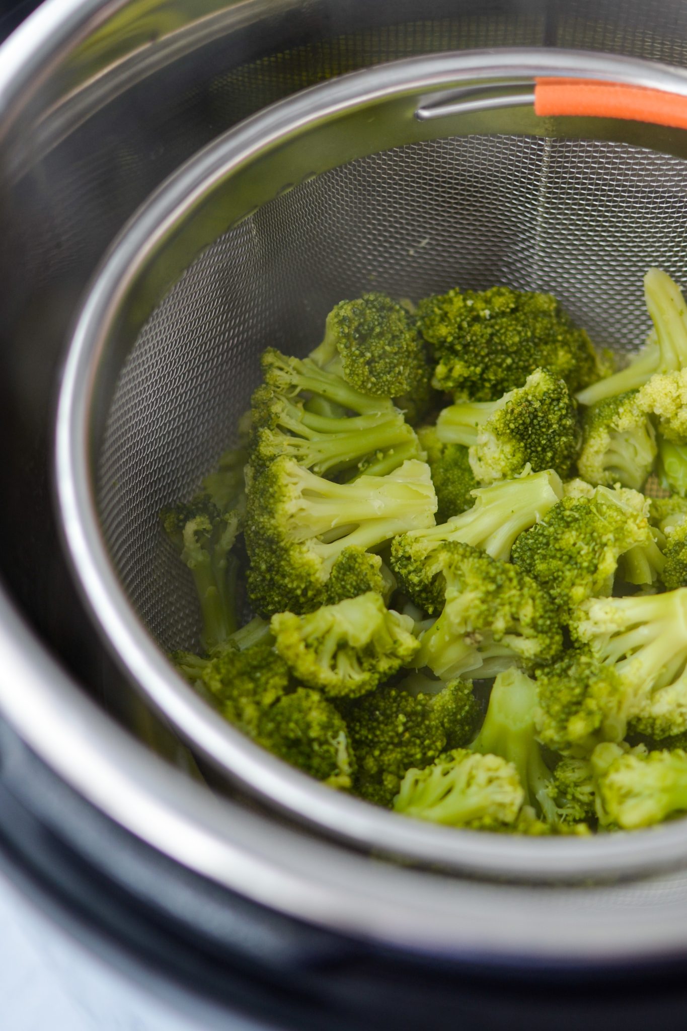 Cooked broccoli inside a steamer basket in the Instant Pot.