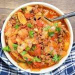 A bowl of cabbage, ground beef, and vegetables, sprinkled with parsley.