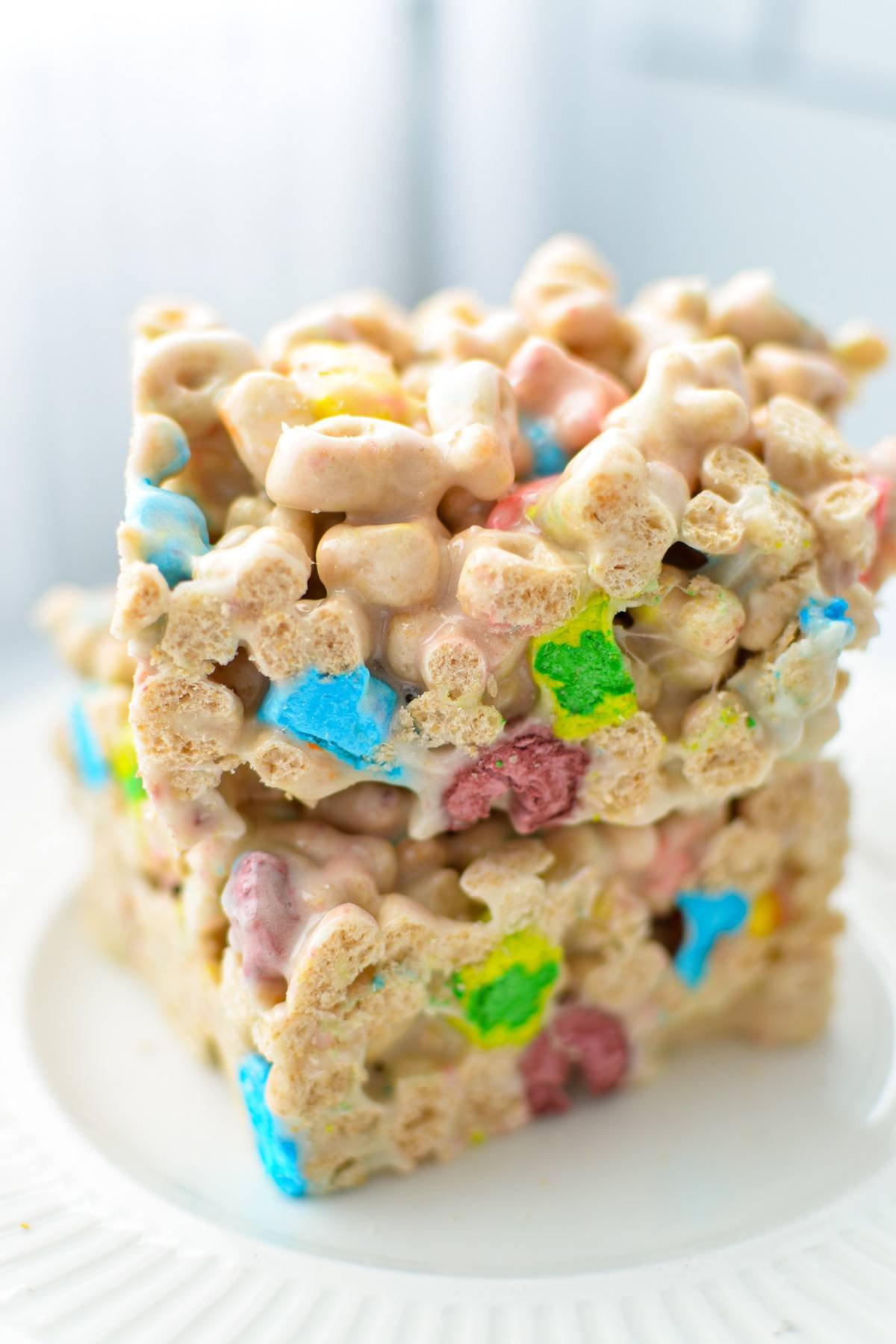 Two lucky charms treats stacked on a white plate. 