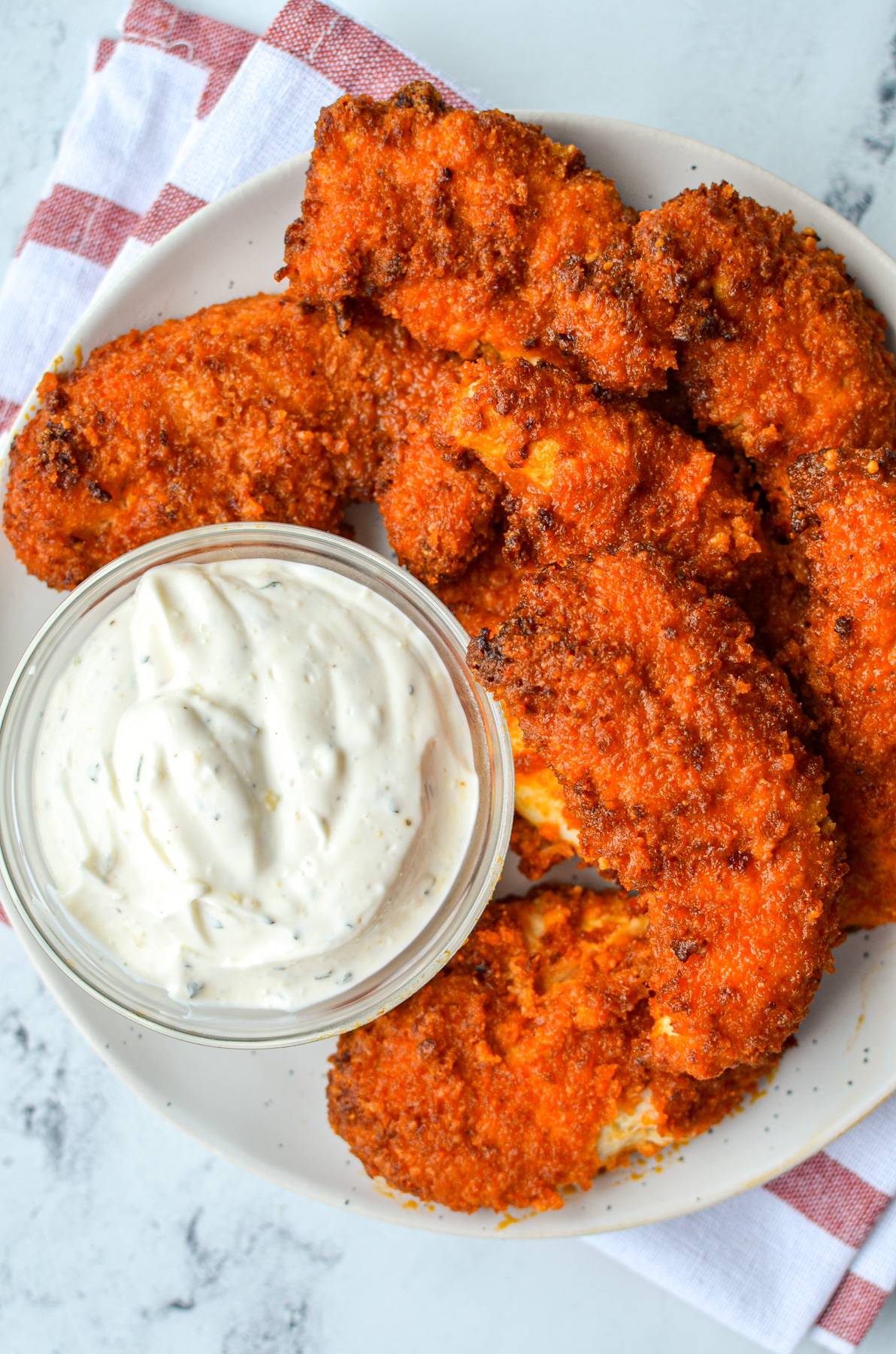 A plate of buffalo chicken tenders with a small bowl of ranch dip.