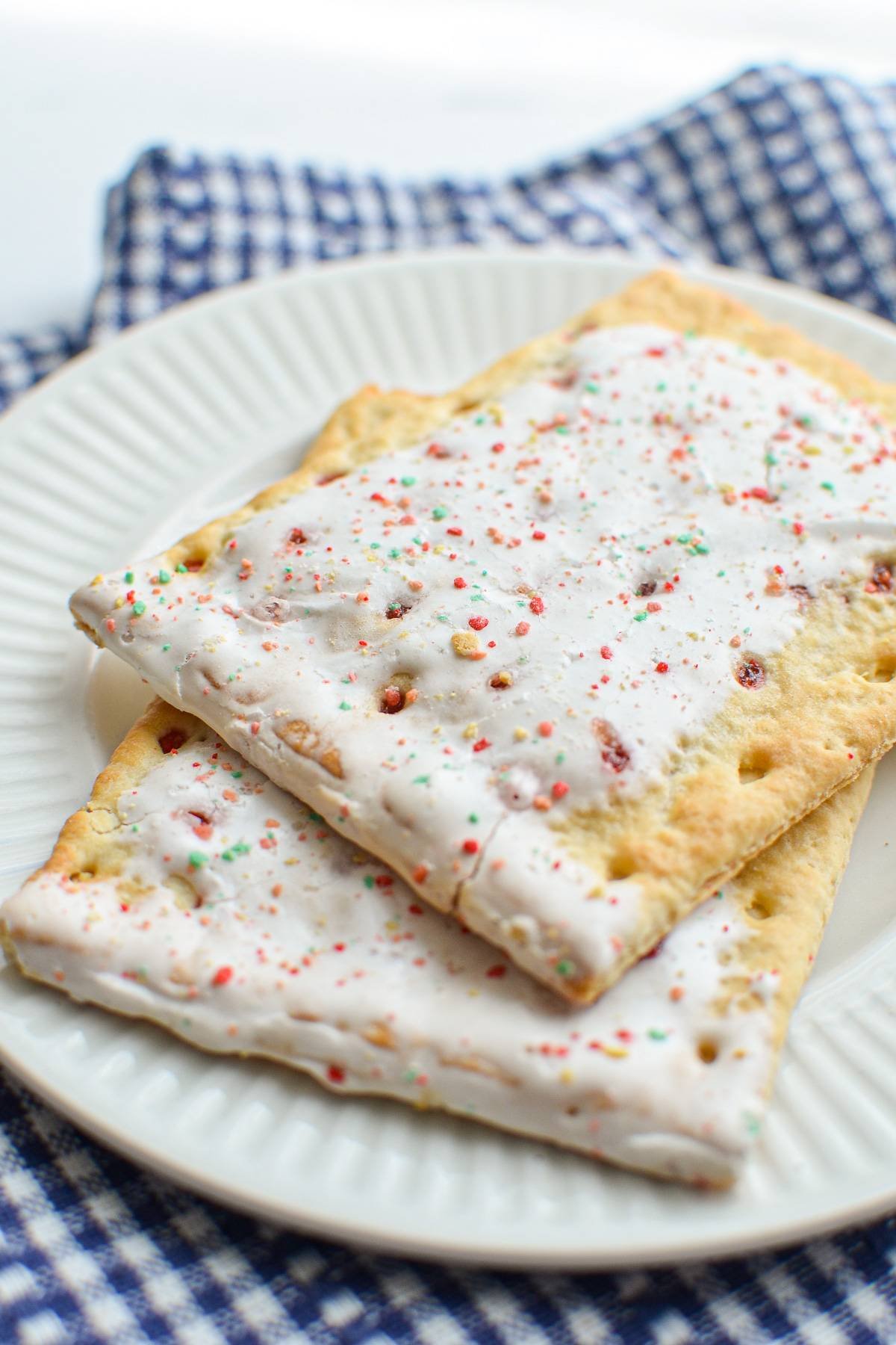 A plate with two strawberry pop tarts layered on top.