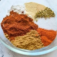 A small bowl filled with various seasonings that come together to make taco seasoning.