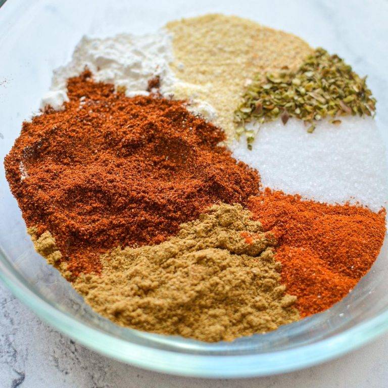 A small bowl filled with various seasonings that come together to make taco seasoning.