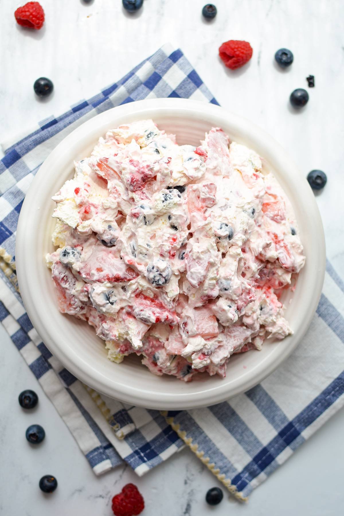 An overhead view of a bowl of red white and blue cheesecake salad.