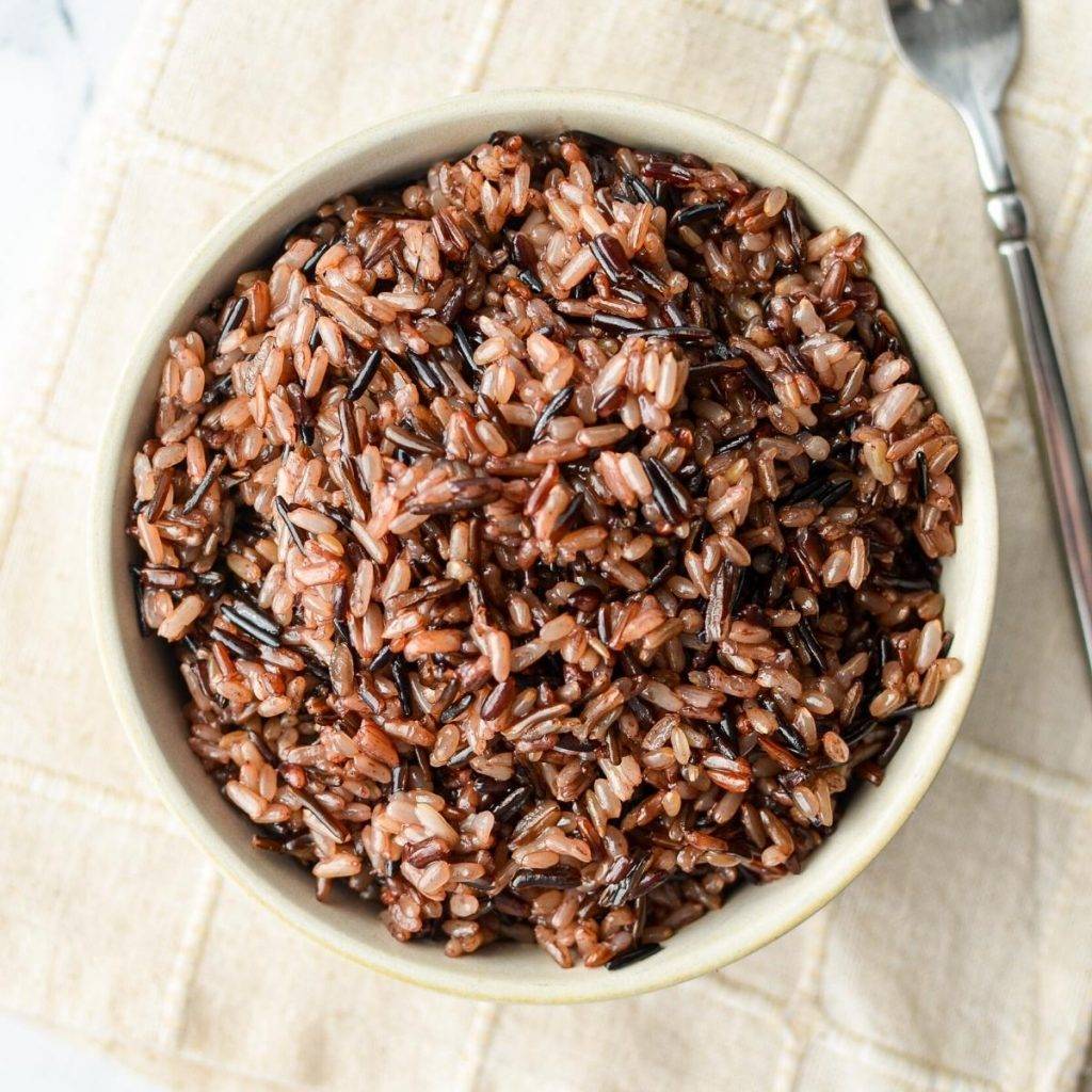 An overhead shot of a bowl of wild rice blend, with a fork on the side.