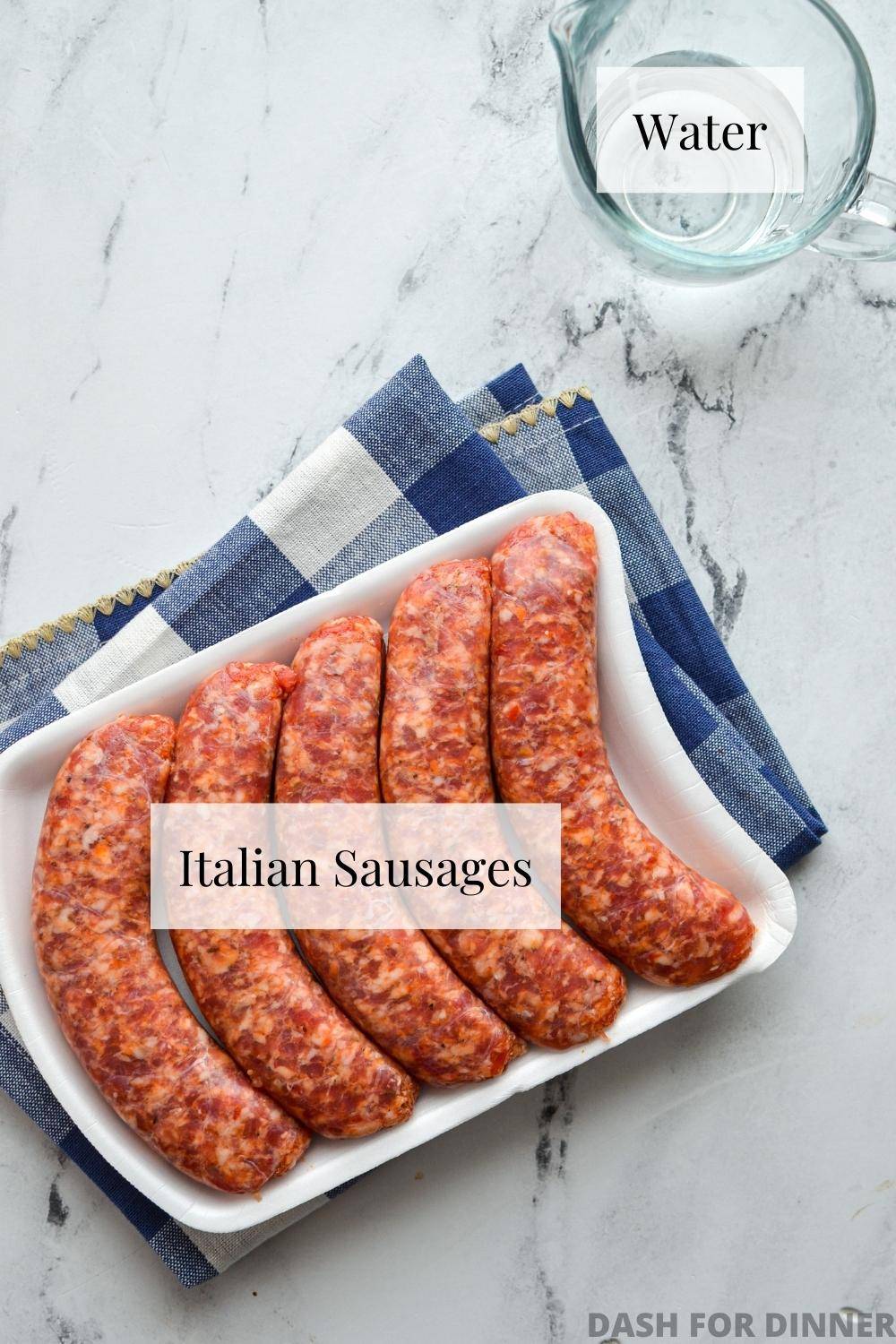 A package of Italian sausages and a small glass cup of water.