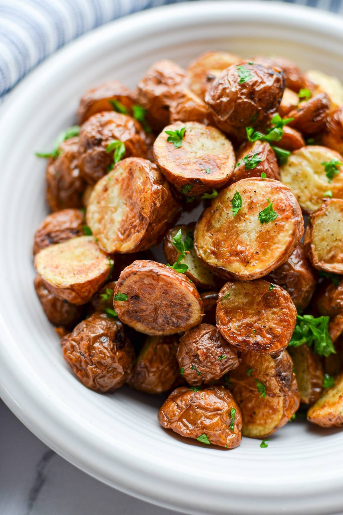 A bowl of baby potatoes with parsley.