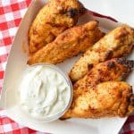 A small takeout box with plain chicken tenders and ranch dip.