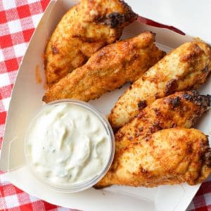 A small takeout box with plain chicken tenders and ranch dip.