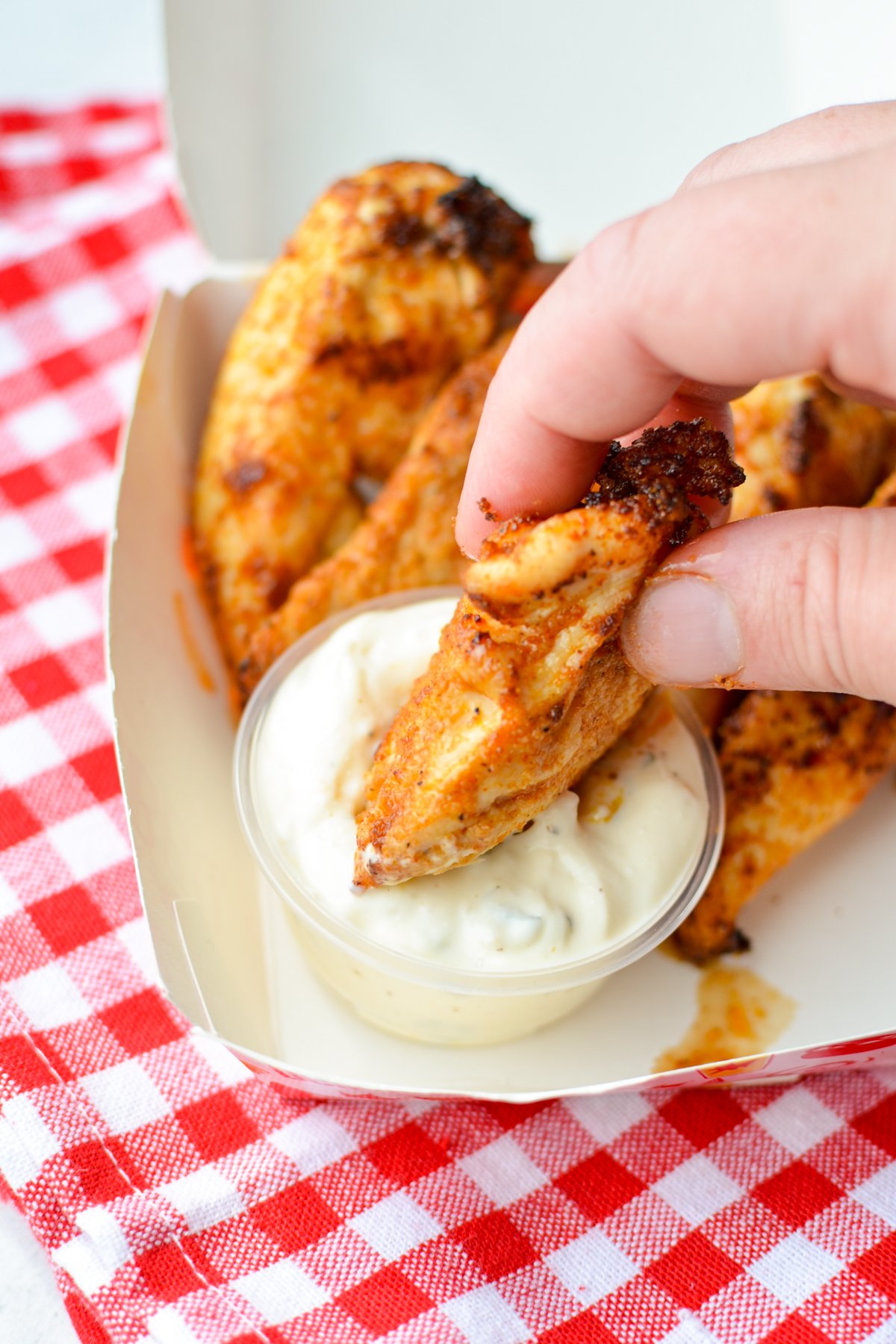 Dipping a chicken tender into ranch dip.