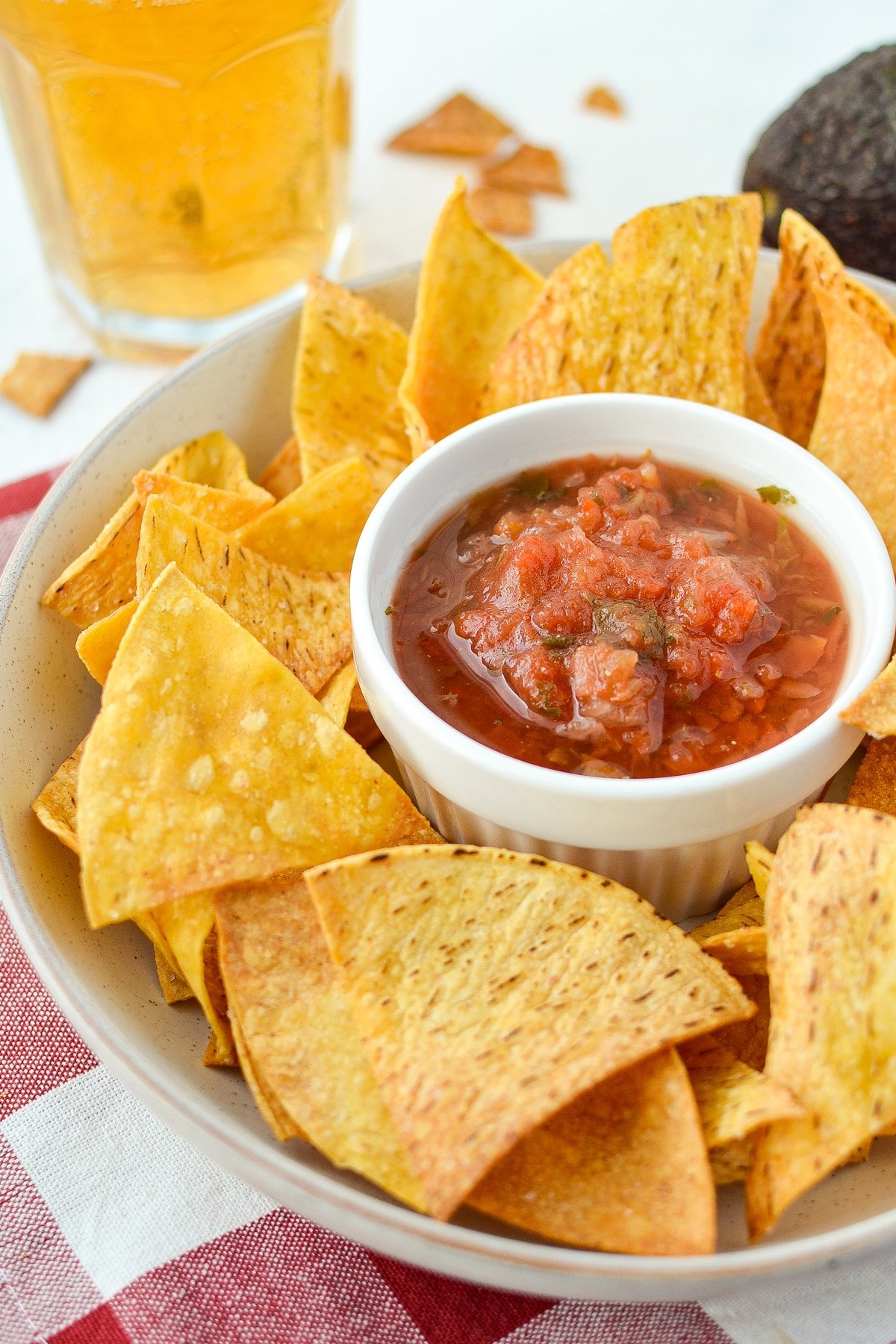 A bowl of tortilla chips with salsa in the middle.