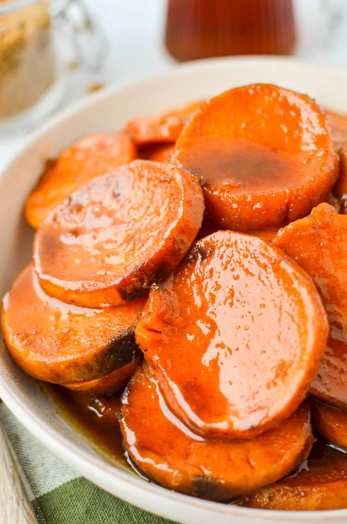 A bowl with sweet potato slices that have been covered in a glaze.