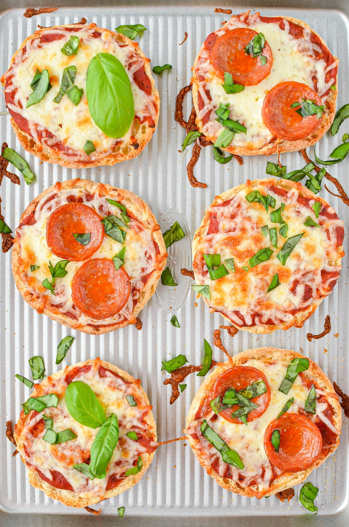 A baking sheet with mini pizzas.
