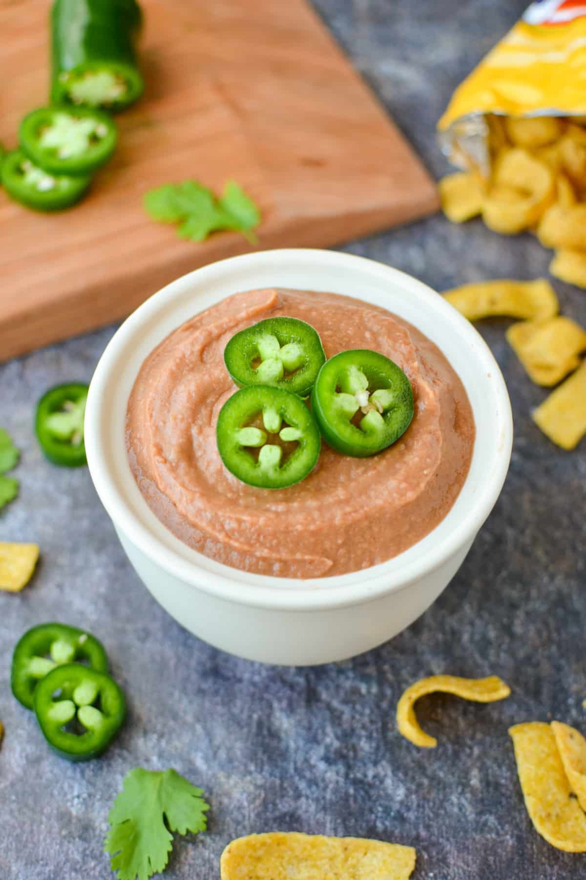 A small bowl of bean dip garnished with jalapeños.