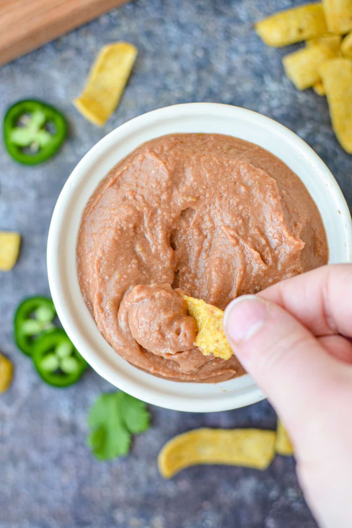 Dipping a corn chip into bean dip.