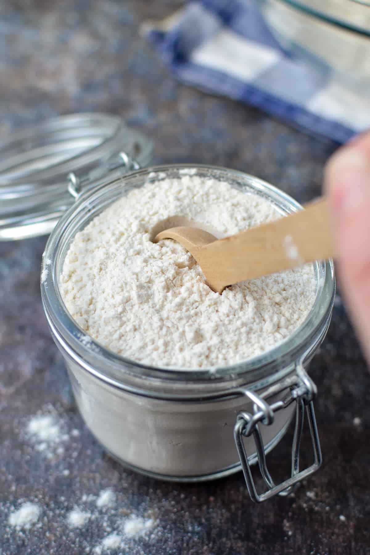 Stirring a small jar of flour.