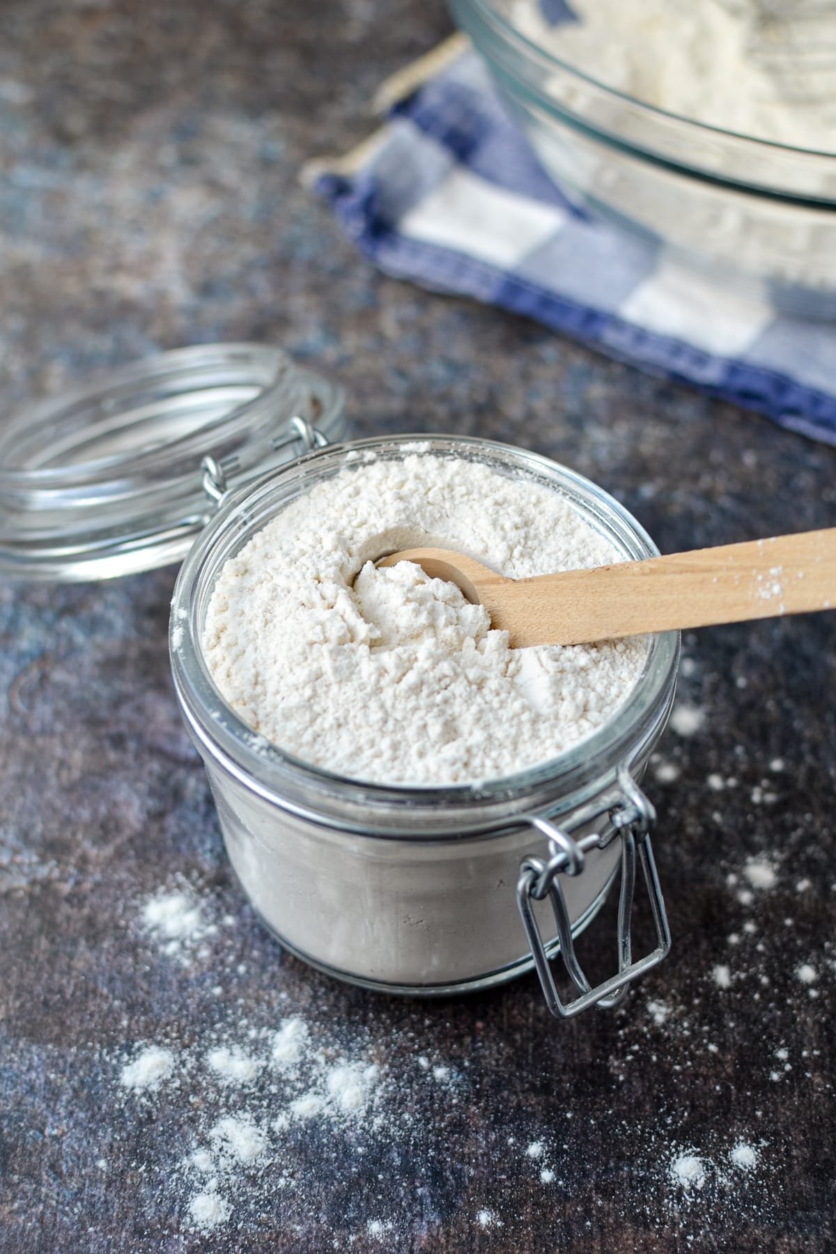 A small jar of flour with a wooden spoon.