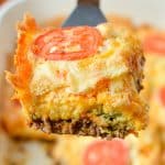 Lifting a square of casserole from a baking dish.