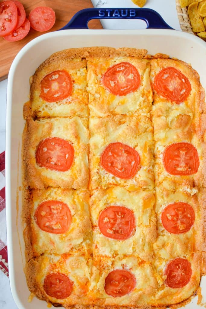 A baking dish with egg and cheese casserole cut into servings.