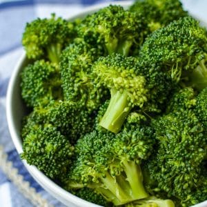 A bowl of broccoli that has been cooked.