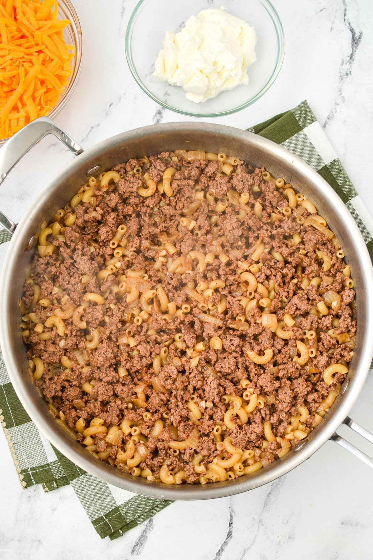 A skillet with ground beef and macaroni.