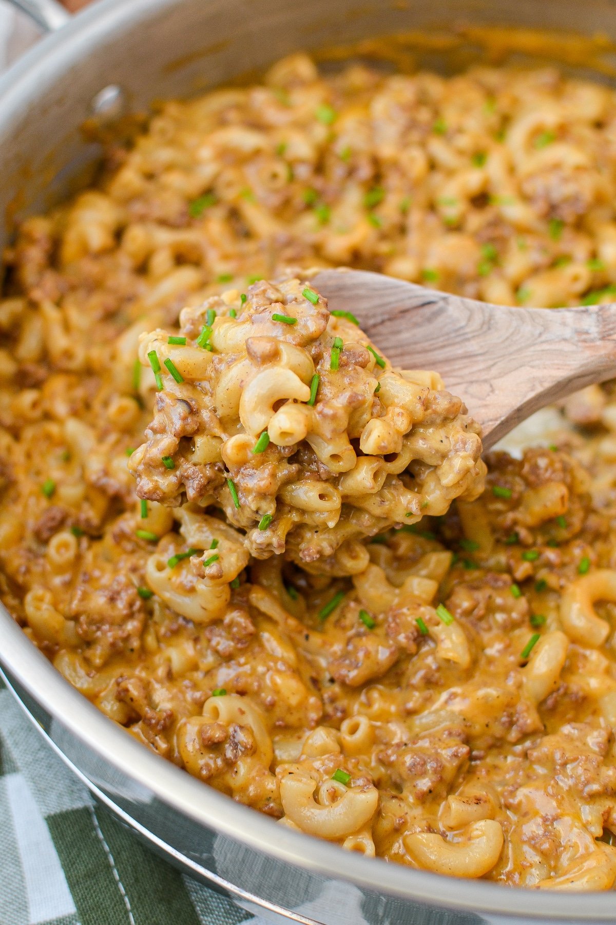 Scooping up a portion of hamburger helper from a skillet.