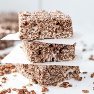 A stack of three cocoa pebbles treats on a marble countertop.