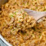 A wooden spoon scooping out a portion of hamburger helper.